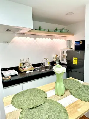 a kitchen with a vase of flowers on a table at HiYara Loft - GA Tower 2, beside MRT BONI Station in Manila
