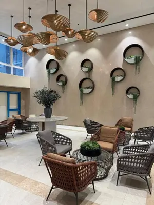 a lobby with chairs and a table and mirrors at New 1BR Condo Near Venice Canal & BGC with Balcony - 7e in Manila