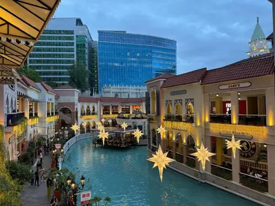 a shopping mall with a river in the middle at New 1BR Condo Near Venice Canal & BGC with Balcony - 7e in Manila