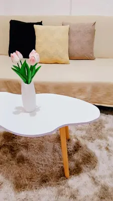 a white coffee table with a vase of flowers on it at Shore Residences Moa Area Pasay City in Manila