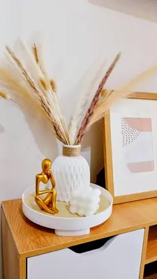 a table with a vase and a plate with feathers at Shore Residences Moa Area Pasay City in Manila