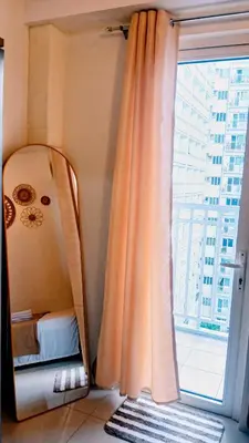 a room with a mirror and a window with a bed at Shore Residences Moa Area Pasay City in Manila