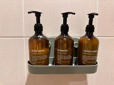 a shelf with four bottles of sauce in it at Cozy, Spacious 1 Bedroom Condo, reach St Lukes BGC by foot in Manila