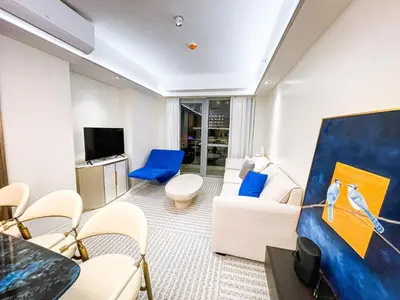a living room with a white couch and blue chairs at Luxury 2BR Penthouse across City of Dreams in Manila