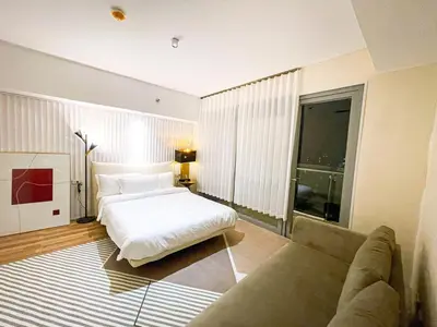 a bedroom with a bed and a couch at Luxury 2BR Penthouse across City of Dreams in Manila