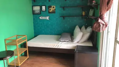a small room with a bed with a green wall at Our home is your castle in Caong