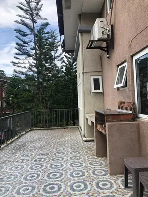 a balcony with a tile floor and a building at Our home is your castle in Caong