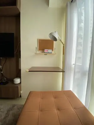 a room with a lamp and a tv and a window at Staycation in Mandaluyong in Manila