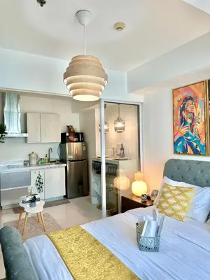 a living room with a bed and a kitchen at Cityscape Staycation by H&B in Manila