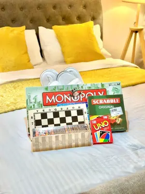 a bed with monopoly and other toys on it at Cityscape Staycation by H&B in Manila