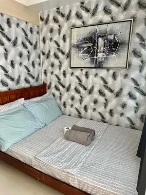 a bed with a bag on it with a wall at Moana's Place Staycation in Manila