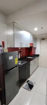 a kitchen with red and white cabinets and a refrigerator at Moana's Place Staycation in Manila