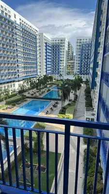 a balcony with a view of a pool and buildings at Moana's Place Staycation in Manila