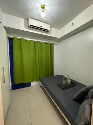 a room with a bed and a green curtain at MOA Complex Staycation in Manila