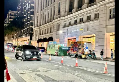 a van driving down a city street with orange cones at D&E suites with balcony in Manila