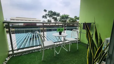 a balcony with a table and chairs and a pool at Jellybean's Snuggly Cabin in Manila