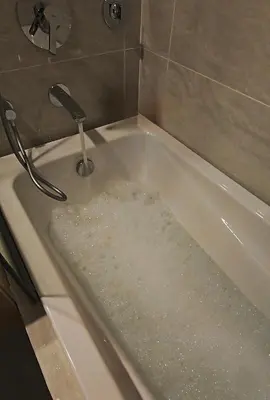 a bath tub filled with water with a faucet at The Imperium Luxury Condominium in Manila