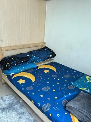 a bed with a blue comforter with moon and stars at Chay place sea residence in Manila