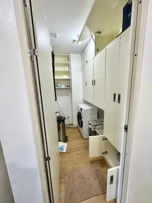 a small kitchen with white cabinets and a microwave at South Residences Tower in Manila