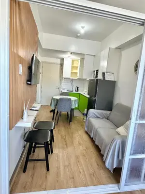 a small apartment with a couch and a table and chairs at South Residences Tower in Manila