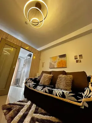 a couch in a living room with a chandelier at Affordable staycation at SHORE RESIDENCES Near MOA and NAIA in Manila