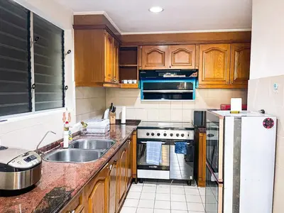 a kitchen with a sink and a refrigerator at Stunning & Luxury 4BR in Manila Bay White Beach in Manila