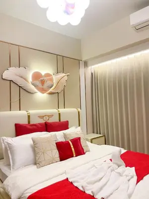 a bedroom with a large bed with red and white pillows at Cozy 3BR in Manila Bay near Okada II 12pax in Manila