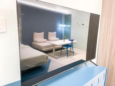 a mirror reflecting a room with a table and a couch at Lovely Penthouse across City of Dreams, Airport in Manila