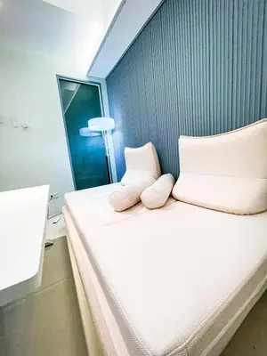 a small bedroom with a bed with two pillows at Lovely Penthouse across City of Dreams, Airport in Manila