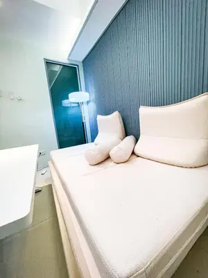a bed with two pillows on it in a room at Lovely Penthouse near Airport, City of Dreams 8pax in Manila