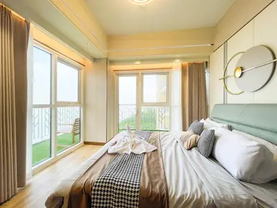 a bedroom with a large bed with a large window at Luxurious 2BR with Manila Bay Sunset II 6pax in Manila