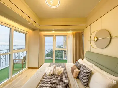 a bedroom with a bed and a large window at Luxurious 2BR with Manila Bay Sunset II 6pax in Manila