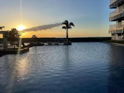 a large pool of water with a sunset in the background at Luxury 2BR beside Okada Manila in Manila