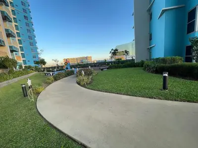 a walkway through a park next to a building at Luxury 2BR beside Okada Manila in Manila