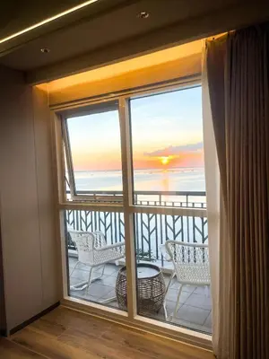 a room with a balcony with a view of the ocean at Luxury 2BR beside Okada Manila in Manila