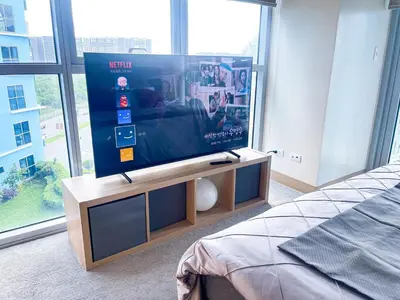 a flat screen tv sitting on a stand in a bedroom at Luxury 2BR Corner near Solaire & Okada II Sunset in Manila