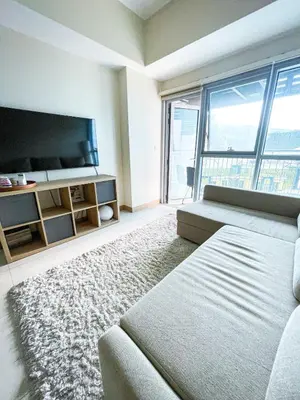 a living room with a couch and a flat screen tv at Luxury 2BR Corner near Solaire & Okada II Sunset in Manila