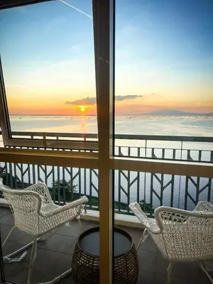 a balcony with chairs and a view of the ocean at Modern 2BR beside Okada Manila with Sunset View in Manila