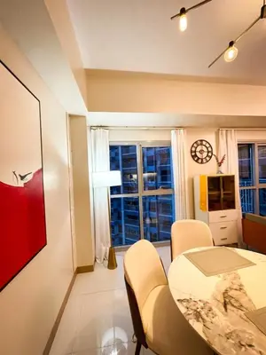 a dining room with a table and chairs and a window at Luxurious 1BR in Bayshore w Sunset View near Okada in Manila