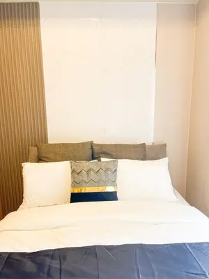 a bed with white sheets and pillows in a room at Modern Luxury 5BR Sunset View beside Okada Manila in Manila