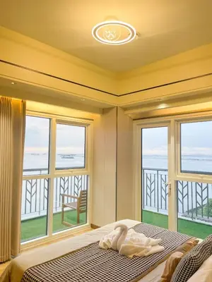 a bedroom with a bed with a view of the ocean at Modern Luxury 5BR Sunset View beside Okada Manila in Manila