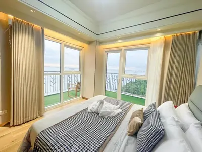 a bedroom with a large bed with a large window at Modern Luxury 5BR Sunset View beside Okada Manila in Manila