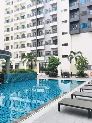 a swimming pool in front of a building at Owls Nest Staycation in Manila