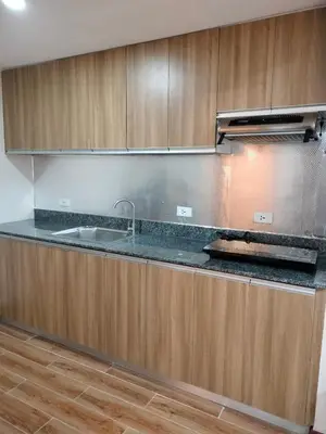 a kitchen with a sink and wooden cabinets at Manila Airport Accommodation at NAIA road in Manila