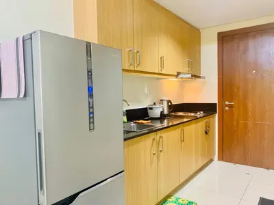 a kitchen with a white refrigerator and wooden cabinets at Sea Residences by Sir Jan 0995-448-8872 in Manila