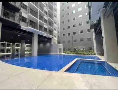 a large swimming pool in the middle of a building at Happy Sunshine at S Residences in Manila