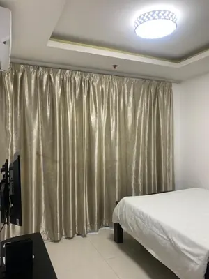 a bedroom with a bed and a curtain at Birch Tower Condominium Malate Manila by T&T in Manila