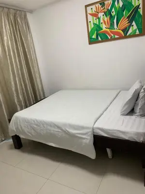 a bed in a room with a picture on the wall at Birch Tower Condominium Malate Manila by T&T in Manila