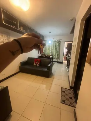 a person holding a video game controller in a living room at Arista Place Condo 2 bedroom unit in Manila