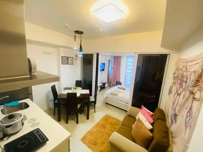 a kitchen and a living room with a couch and a table at Sole Sisters Staycation in Manila